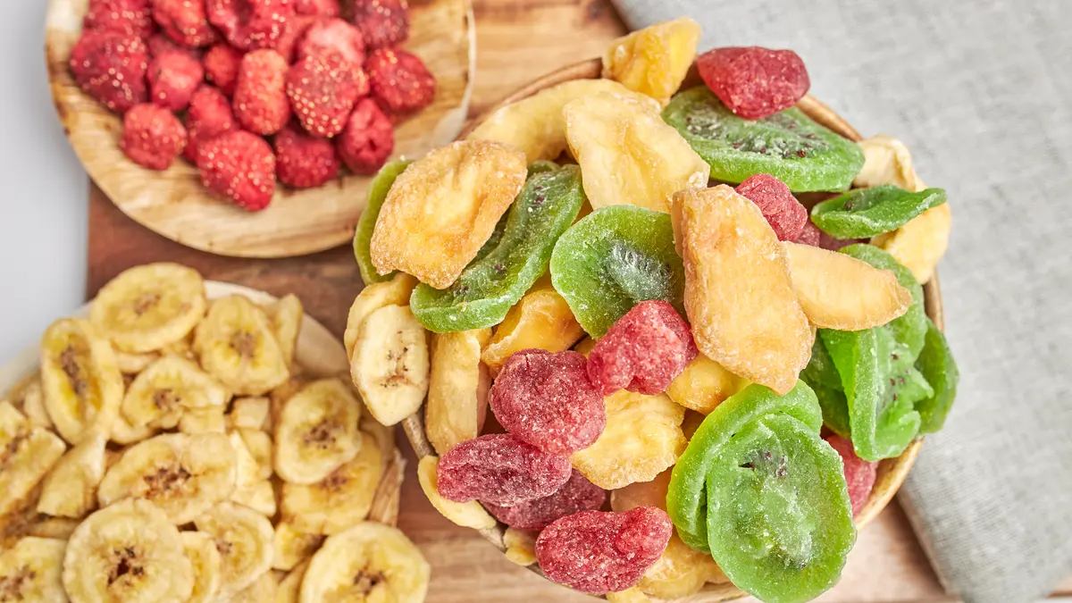 Verschiedene Teller mit gefriergetrocknetem Obst wie Erdbeeren, Bananen und Kiwi