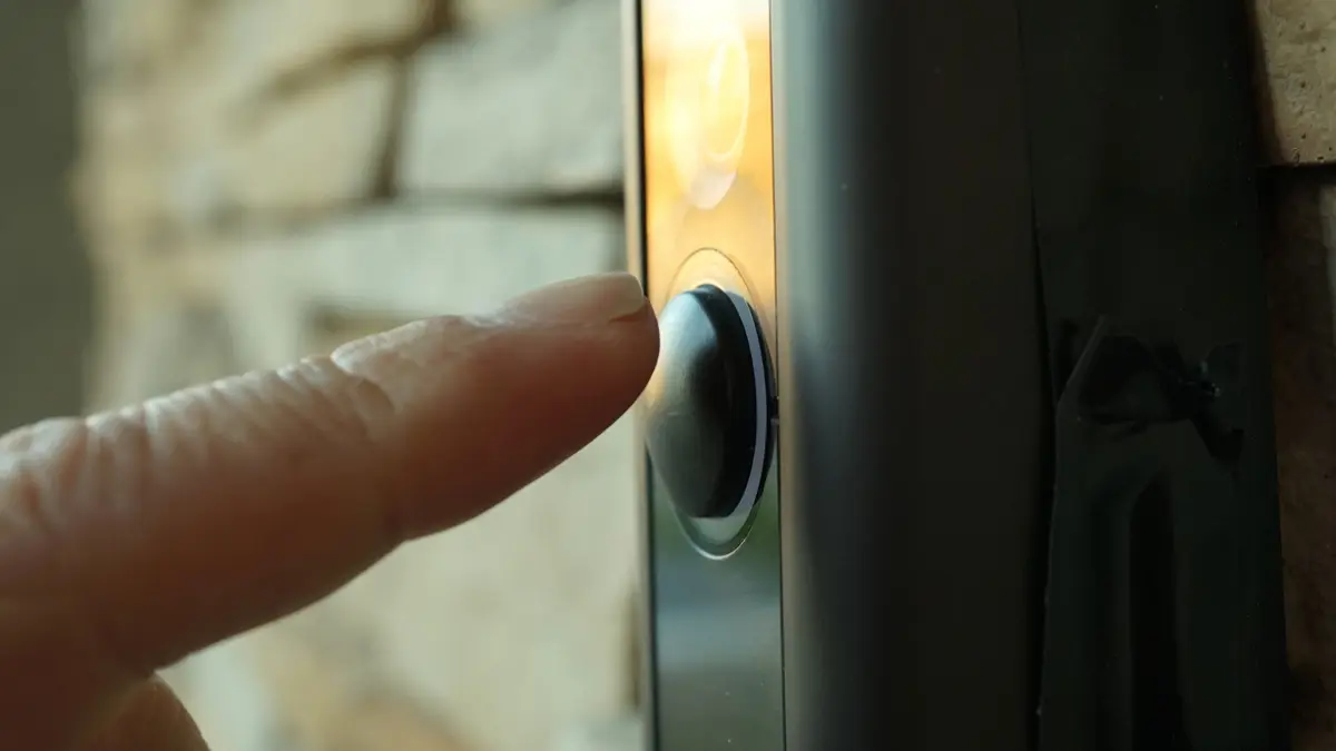 Ein Finger betätigt eine Haustürklingel