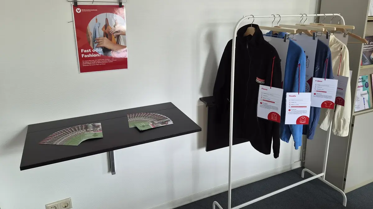 Info-Ecke zum Thema Fair Trade mit Plakaten und einer Kleiderstange