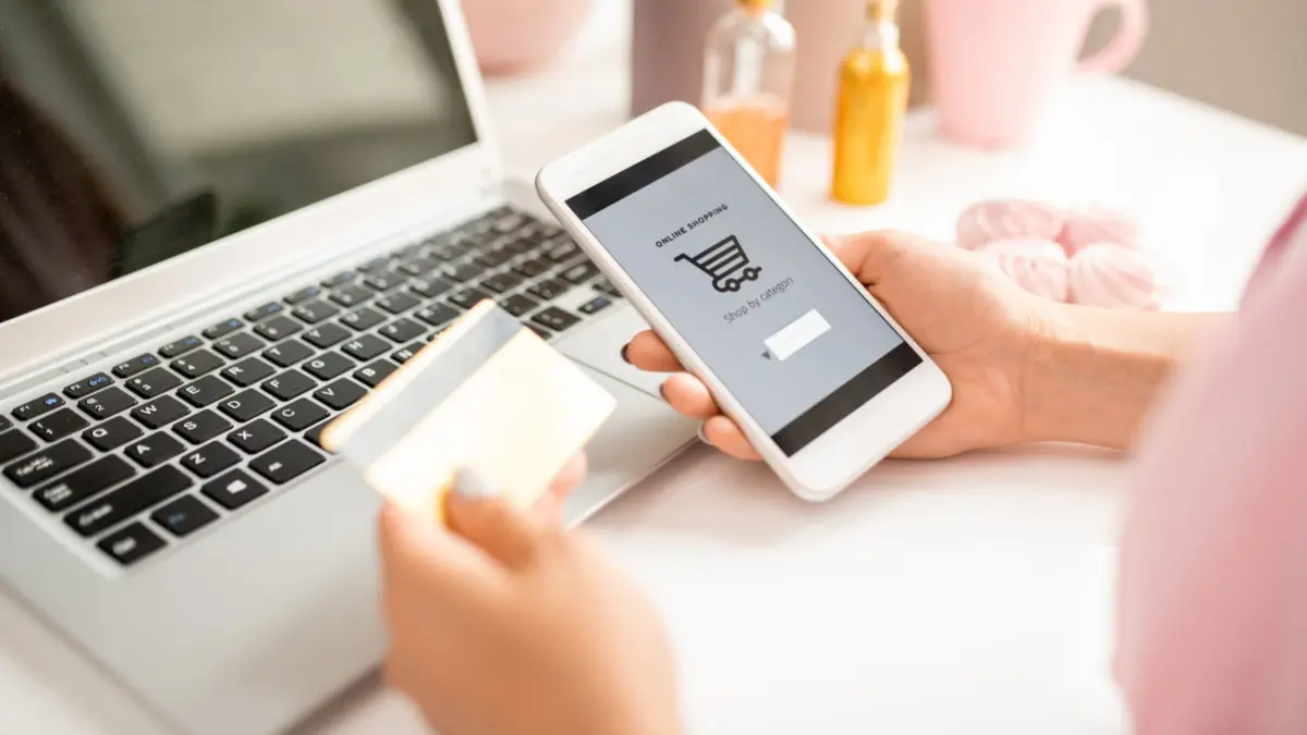 Frau mit Smartphone und Kreditkarte beim Onlineshopping