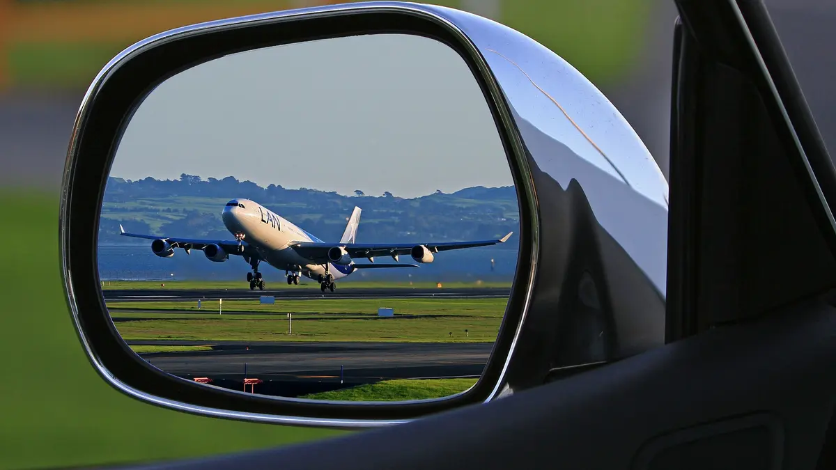 Flugzeug spiegelt sich im Rückspiegel eines Autos