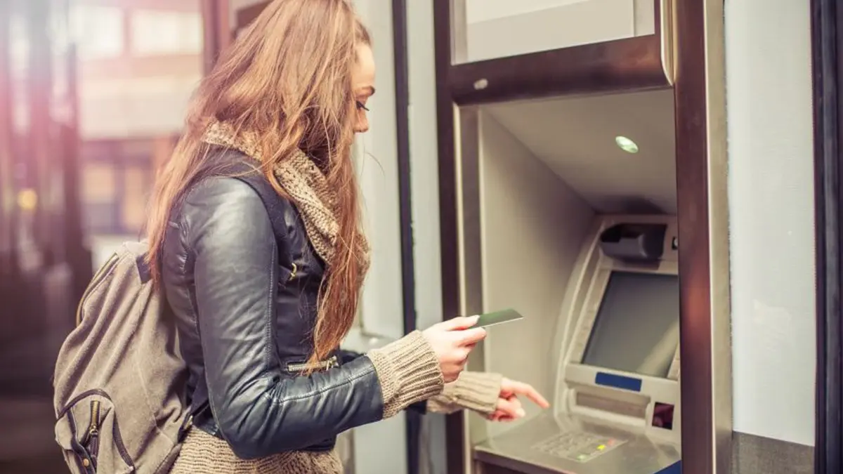 Junge Frau am geldautomat Finanzen