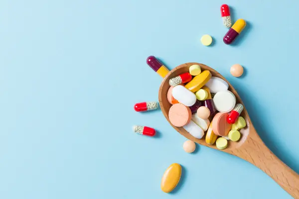 Viele unterschiedliche Tabletten auf einem Löffel