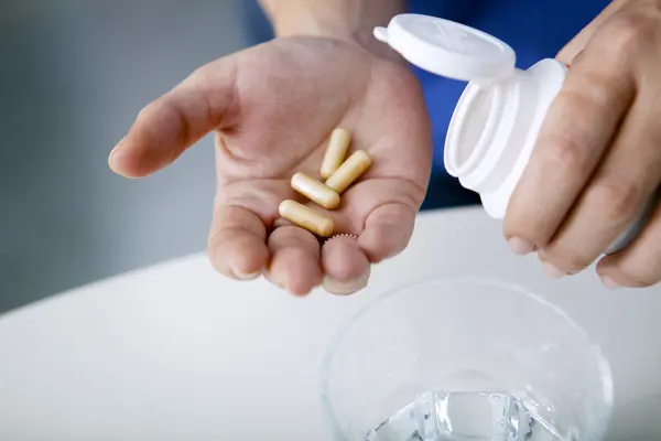 Tabletten für Nahrungsergänzungsmittel auf Handfläche geschüttet