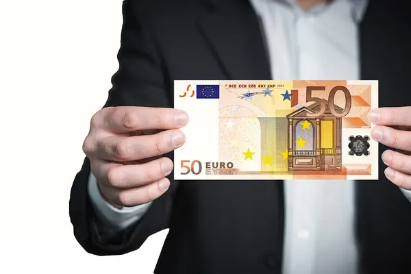 Eine Person hält einen 50-Euro-Schein in den Händen.