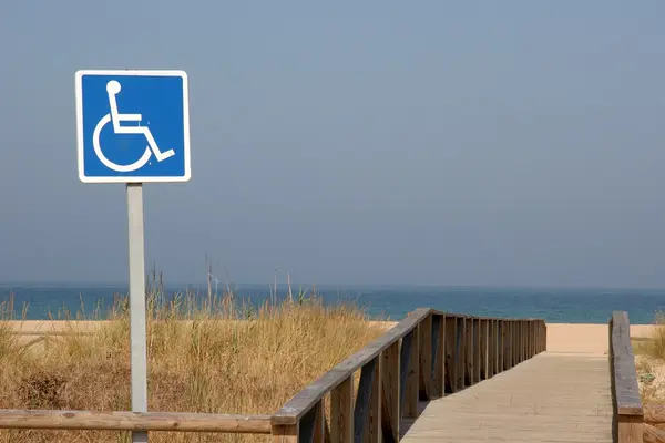 Schild mit Rollstuhl am Strand.