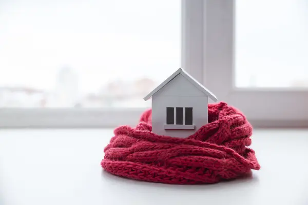 Ein Haus wird mit einem Schal gewärmt