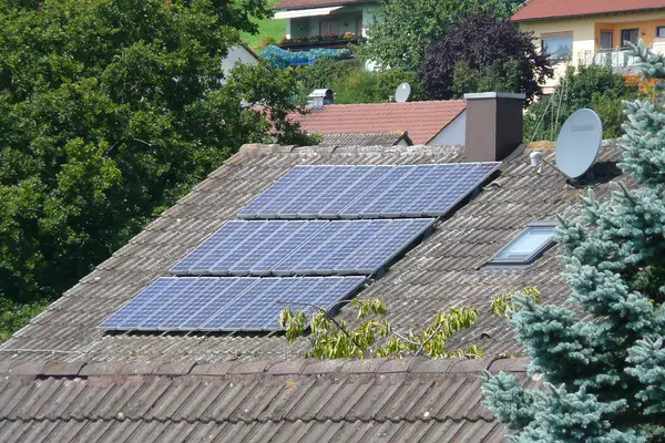 Eine alte Solaranlage auf einem Hausdach.