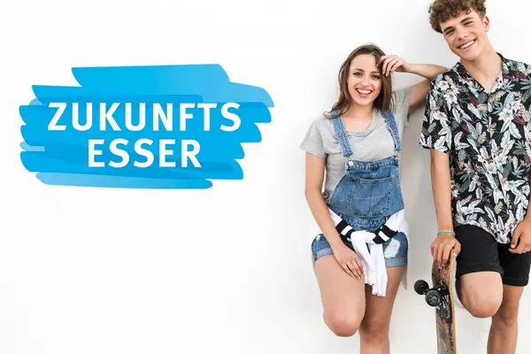 Neben einem Schriftzug "Zukunftsesser" stehen Teenager mit einem Skateboard