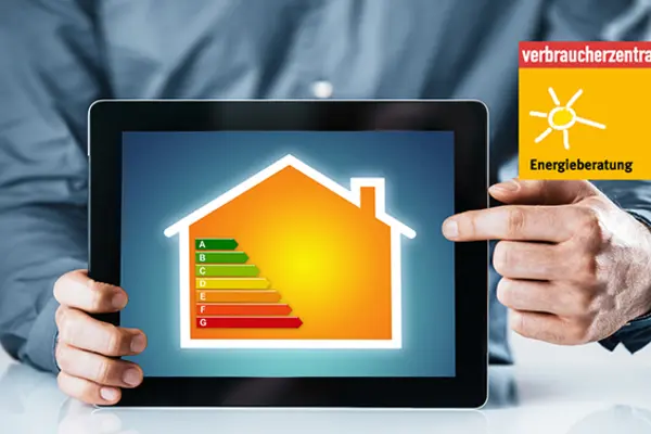 Ein Mann, dessen Torso zu sehen ist, zeigt ein Tablet in die Kamera, auf dem ein gelbes Haus zu sehen ist. Im Bild des Hauses sind die verschiedenen Energieeffizientstufen zu sehen.