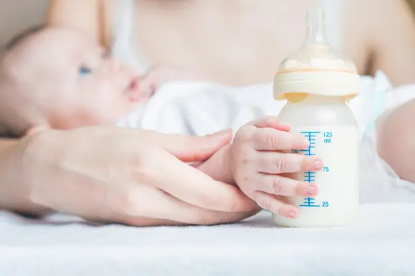 Baby hält ein Fläschchen mit Milch