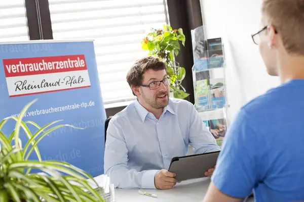 Zwei Personen an einem Schreibtisch im Gepräch.