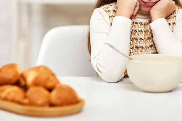 Mädchen sitzt am Frühstückstisch und isst nicht
