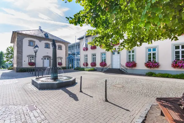 Ein großer Platz mit Häusern udn einem Brunnen in der Mitte.