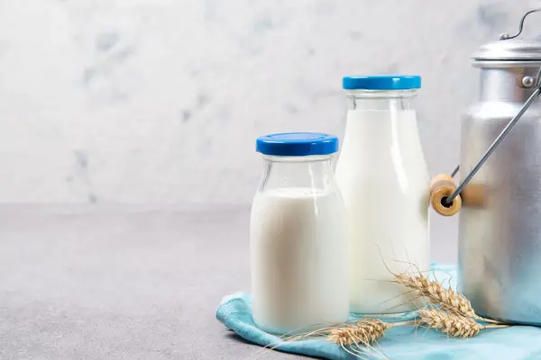 Milchflaschen und eine Milchkanne auf einem Tisch
