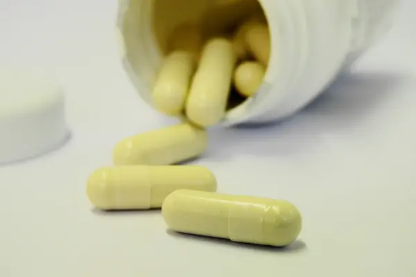 Eine offene Dose mit Pillen als Nahrungsergänzungsmittel