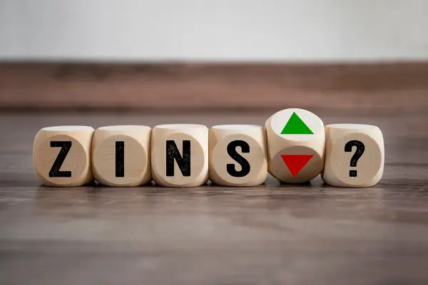 Würfel mit der Aufschrift "Zins" und Pfeilen die nach oben und unten zeigen. 