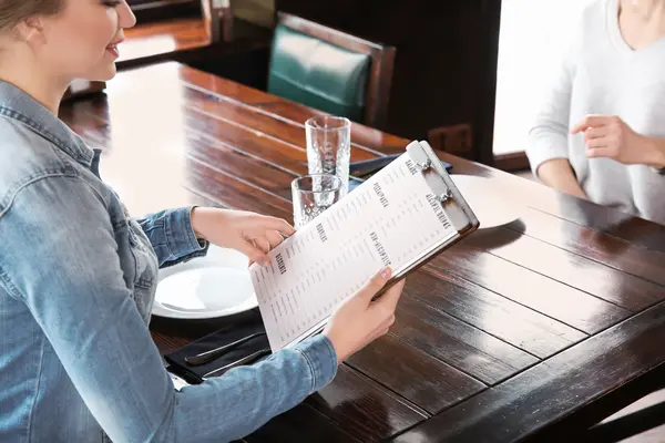 Personen schauen Speisekarte im Restaurant an
