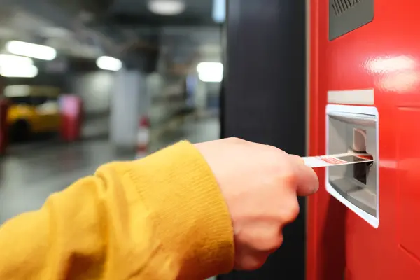 Ein Fahrgast zieht ein Ticket über einen Fahrkartenautomaten.