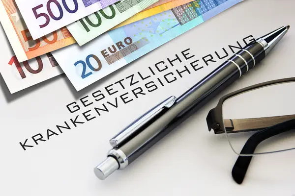 Geldscheine und ein Stift liegen auf einem Dokument zur gesetzlichen Krankenversicherung