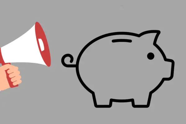 Ein Megafon neben einem Sparschwein.