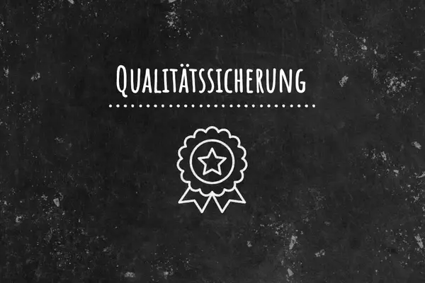 Schwarze Tafel mit Schriftzug Qualitätssicherung und Kreidebild eines Abzeichens