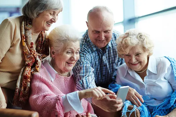 Vier Seniorinnen und Senioren mit Smartphone  