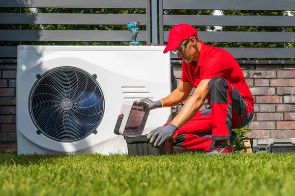Mann arbeitet an Wärmepumpe
