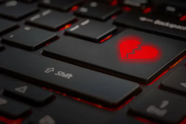 Eine Tastatur in der Nahaufnahme. Anstelle der Entertaste befindet sich das Symbol eines gebrochenen Herzens