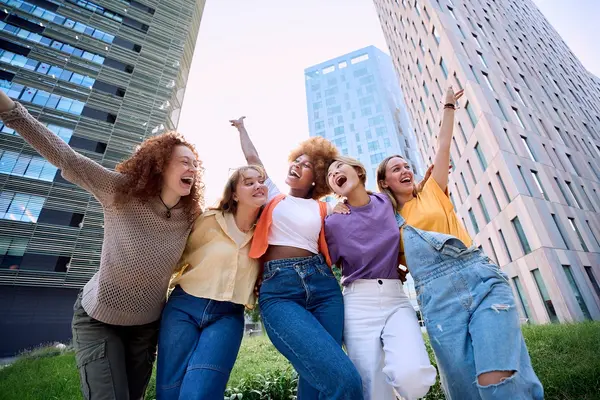 Fünf junge Frauen Arm in Arm.