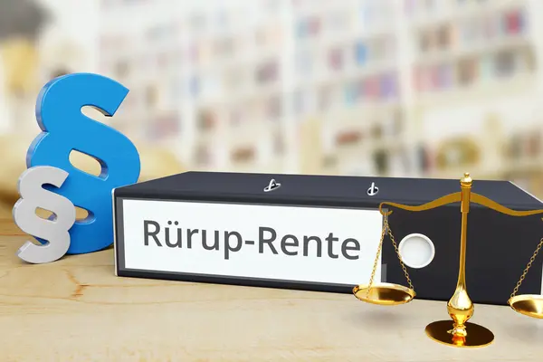 Ein Aktenordner mit der Aufschrift "Rürup-Rente" liegt auf einem Tisch, links daneben zwei Paragraph-Zeichen.