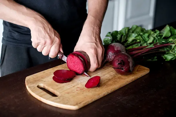 Frau schneidet rote Beete