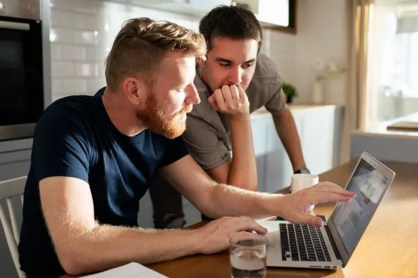 Zwei Männer sitzen vor einem Laptop
