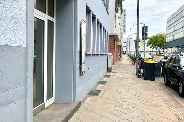 Straße mit parkenden Autos, Eingang eines Hauses mit der Hausnummer 63