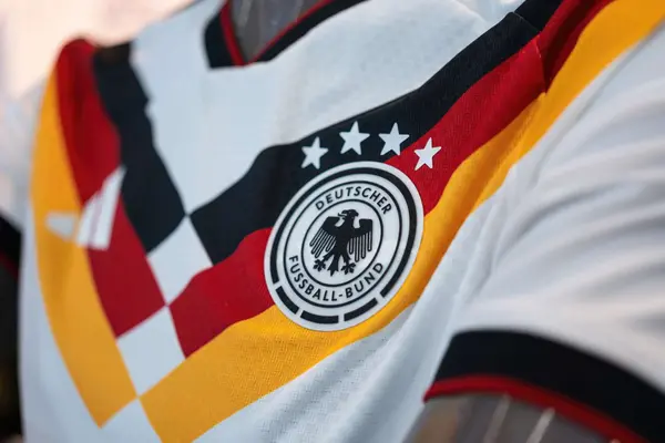 Nahaufnahme des weißen DFB-Heimtrikots für die WM 2026 mit dem runden Logo des Deutschen Fußball-Bundes und vier Weltmeister-Sternen.