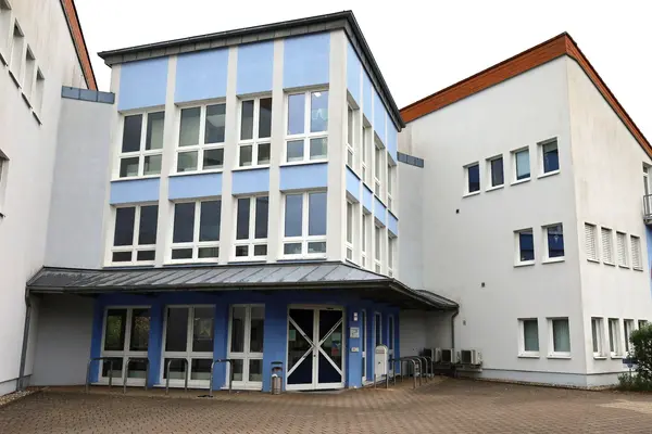 Eingangsbereich eines dreistöckigen öffentlichen Gebäudes mit vielen Fenstern