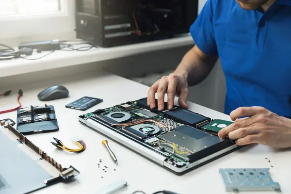 Mann repariert Laptop