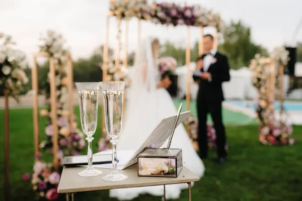 Hochzeit im Garten mit zwei Sektkelchen im Vordergrund