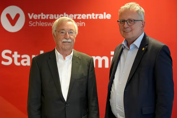 Zwei Männer stehen vor einer Messewand