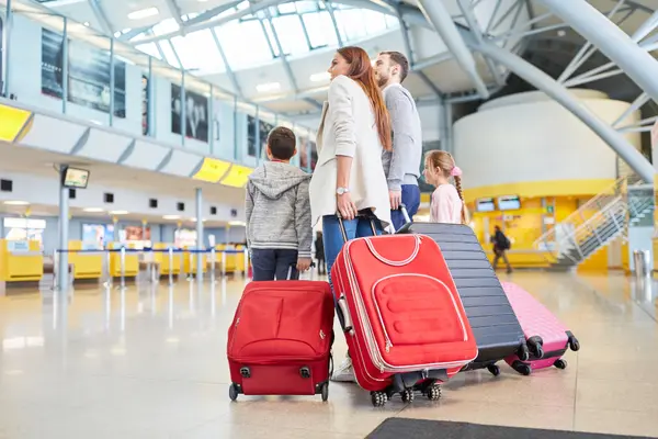 Familie mit Koffern am Flughafen