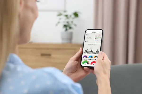 Frau schaut auf Handy dynamische Stromtarife an