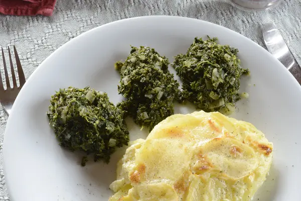 Kartoffelgratin und Grünkohl auf einem Teller
