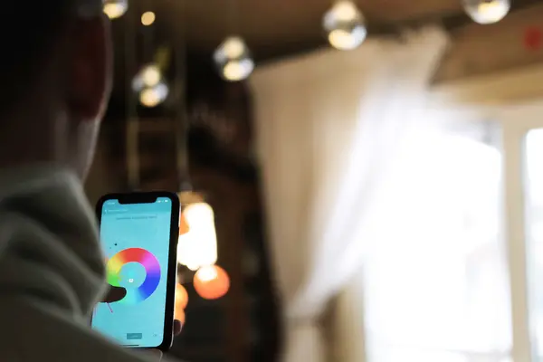 Mann steuert sein Licht mit dem Smartphone