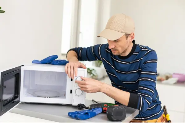 man repairing mikrowave