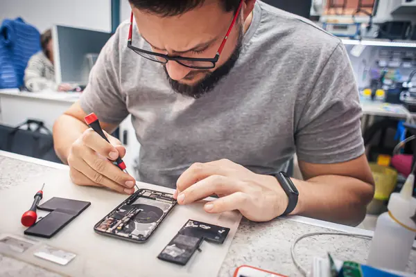 Mann repariert Smartphone
