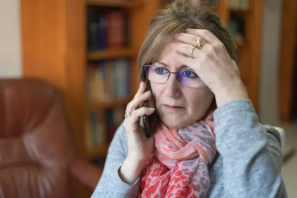 Frau am Telefon erreicht ein Schockanruf