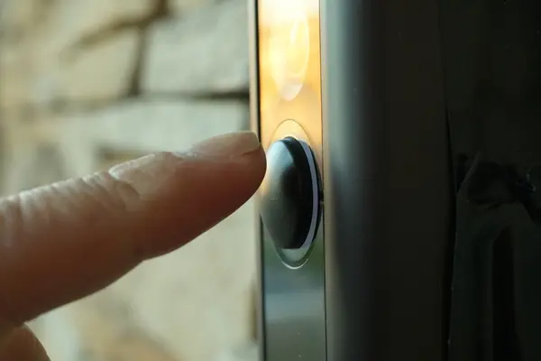 Ein Finger betätigt eine Haustürklingel