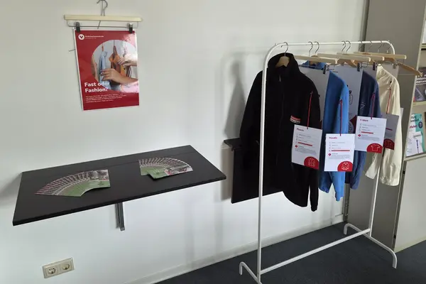 Info-Ecke zum Thema Fair Trade mit Plakaten und einer Kleiderstange