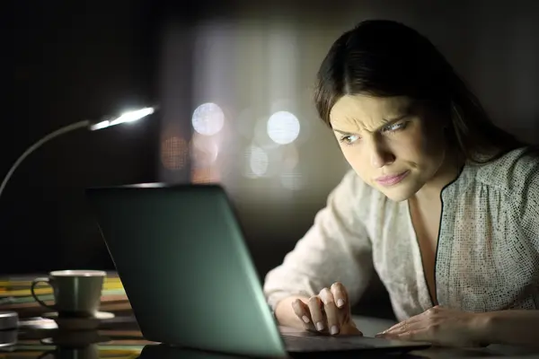 Frau blickt konzentriert und skeptisch auf einen Laptop.