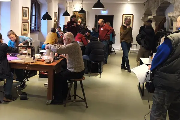Eine Gruppe von Menschen repariert gemeinsam im Repair-Café. 